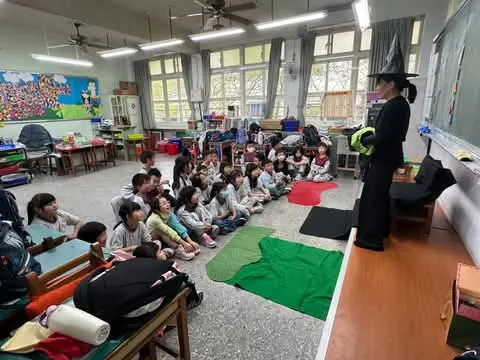 The witch teacher telling a story to young children in class