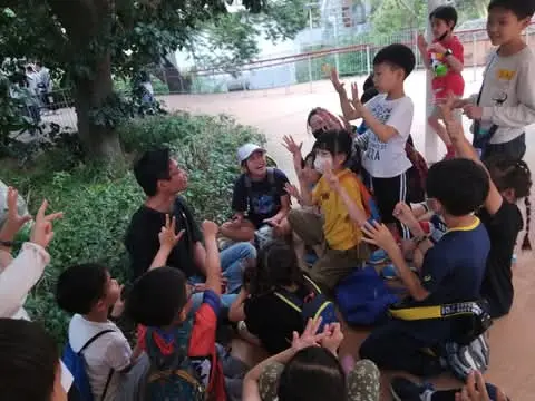 A zoo roving guide leading children on an outdoor observation